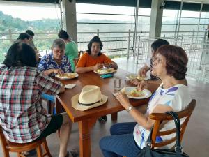 een groep mensen die aan een tafel eten bij Crown & Crown Kandy in Kandy