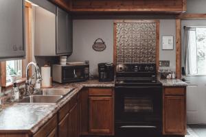 una cucina con piano cottura nero e lavandino di Patriot Cottage at American Heartland Cabins a Rockbridge