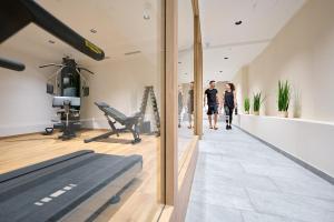 a man and a woman walking through a gym at Hotel Gamsleiten in Obertauern