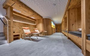 a hallway with two chairs and wooden walls at Hotel Gamsleiten in Obertauern