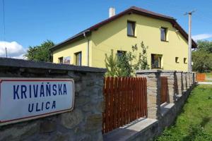 a yellow house with a sign in front of it at Apartmán Beáta in Levoča