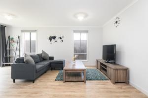 a living room with a couch and a tv at 3bedroom Modern Home in Mt Barker, 8km to Hahndorf in Mount Barker