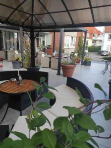 a patio with a table and chairs under a tent at Hotel Oyten am Markt in Oyten