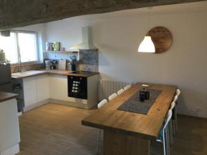 una cocina con una gran mesa de madera en una habitación en gites de terophey & kena, en Thiberville