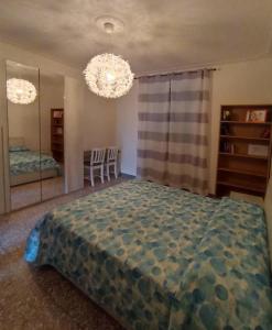 Un dormitorio con una cama grande y una lámpara de araña. en La casa di Ali en Abbadia San Salvatore