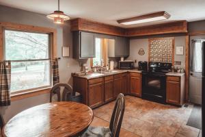 cocina con armarios de madera, mesa y ventana en Patriot Cottage at American Heartland Cabins, en Rockbridge