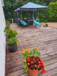 a wooden deck with flowers and a gazebo at Tullyvinney Lodge in Raphoe