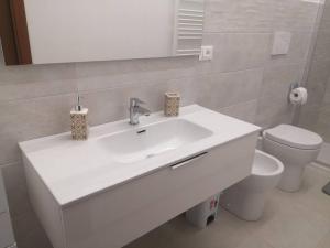 ein Badezimmer mit einem weißen Waschbecken und einem WC in der Unterkunft A Casa di Amici in Arezzo