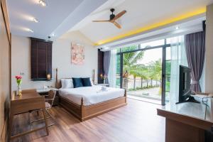 Un dormitorio con una cama y un televisor en una habitación. en HOLLYWOOD Luxury PoolVilla Pattaya walking street 4 Bedrooms, en Pattaya South