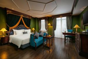a hotel room with a bed and a blue chair at Le Chanvre Hanoi Hotel & Spa in Hanoi