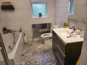 a bathroom with a tub sink and a toilet at Tullyvinney Lodge in Raphoe