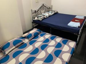 a twin bed with a blue and white comforter at VN GRAND RESIDENCY in Kottakupam
