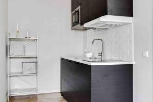 a kitchen with a sink and a refrigerator at Bright apartment in park environment in Lund