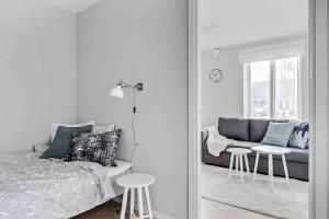 a bedroom with a bed and a couch and a mirror at Bright apartment in park environment in Lund