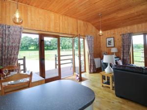 a living room with a couch and a table at Barn Shelley Lodge in Copplestone