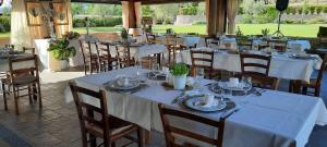jadalnia z białymi stołami i krzesłami w obiekcie Agriturismo Poggetto w mieście Larciano