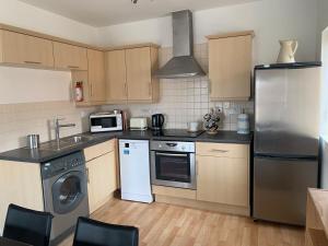 a kitchen with a stainless steel refrigerator and a dishwasher at 2 Bed Apartment Close To Open Countryside in Kidlington