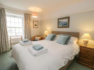 1 dormitorio con 1 cama blanca grande y toallas. en Garth Craig en Porthmadog