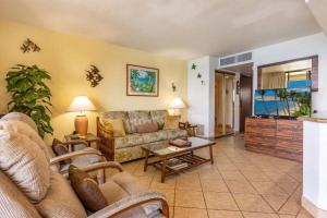 a living room with a couch and a flat screen tv at KIHEI BEACH, #507 condo in Kihei