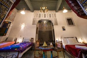 Fes Antique Hostel في فاس: غرفة بسريرين وطاولة فيها