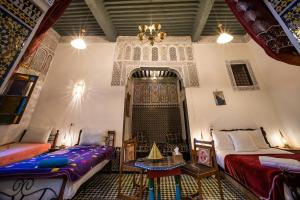 een kamer met twee bedden en een tafel erin bij Fes Antique Hostel in Fès