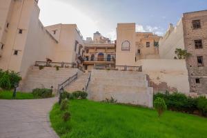 a group of buildings with stairs and grass in front at Fes Antique Hostel in Fès