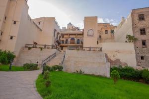 a group of buildings with stairs and grass in front at Fes Antique Hostel in Fez