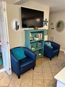 sala de estar con 2 sillas azules y TV en Mini Pearl, Private 2 BR - 1 block to BEACH! en Tybee Island