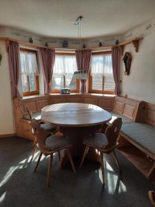 a dining room with a wooden table and chairs at Landhaus Müller in Jungholz