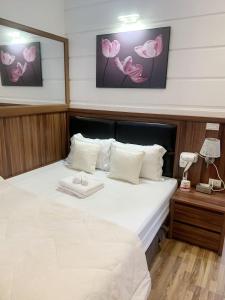 GRAD Dai Thanh Hotel في هانوي: غرفة نوم مع سرير مع ملاءات بيضاء وورود وردية