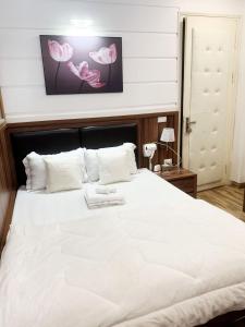 a bedroom with a large white bed with white pillows at GRAD Dai Thanh Hotel in Hanoi