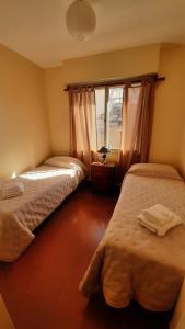 ein Schlafzimmer mit zwei Betten und einem Fenster in der Unterkunft ALTOS JUJUY ALQUILER TEMPORARIO in San Salvador de Jujuy