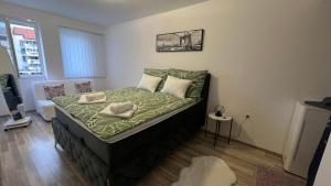 Apartman Stil في بوغوينو: غرفة نوم بسرير وملاءات ووسائد خضراء
