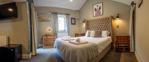 a bedroom with a large bed and a television at The Lower Buck Inn in Clitheroe