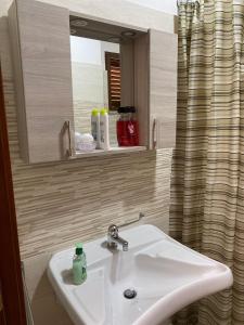 W łazience znajduje się biała umywalka i lustro. w obiekcie Masseria da Federica w mieście Tufo