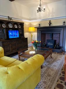 a living room with a yellow couch and a fireplace at Moresby Hall Country House Hotel in Whitehaven