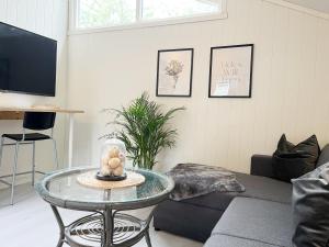 a living room with a glass table and a couch at Brightside Apartment in Kristiansand