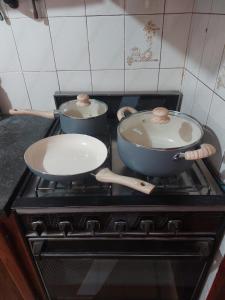 two pots and pans sitting on top of a stove at Casa Silvia - Zona Palmares in Godoy Cruz
