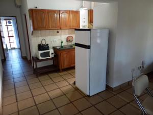 a kitchen with a white refrigerator and a microwave at Casa Silvia - Zona Palmares in Godoy Cruz