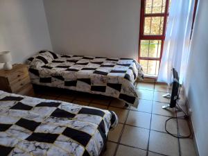 a bedroom with two beds and a window at Casa Silvia - Zona Palmares in Godoy Cruz