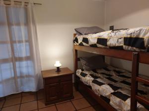a bedroom with a bunk bed with a lamp on a table at Casa Silvia - Zona Palmares in Godoy Cruz