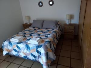 a bedroom with a bed with a colorful comforter at Casa Silvia - Zona Palmares in Godoy Cruz