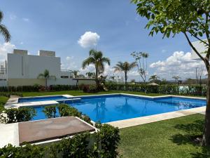 een zwembad in een tuin met bomen en een gebouw bij La mejor opción para el fin, semana y mes. in Oaxtepec