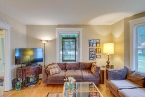 uma sala de estar com um sofá e uma televisão em Historic Home with Sunroom - 5 Mi to Lambeau Field! em De Pere