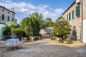 a courtyard with a table and chairs and plants at B&B Corte dei Ducati in Comacchio