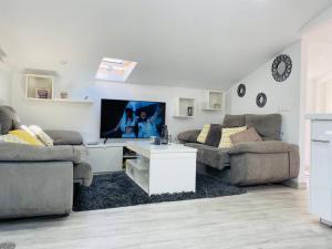 - un salon avec deux canapés et une télévision à écran plat dans l'établissement Ático combarro, à Combarro
