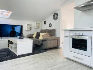 a living room with a couch and a tv at Ático combarro in Combarro