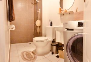 馬尼拉的住宿－Studio Balcony Pool Videoke Cityscape Laundry，一间带卫生间和洗衣机的浴室