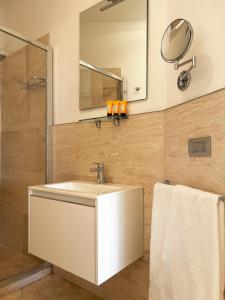 a bathroom with a white sink and a mirror at Suite con giardino in La Maddalena