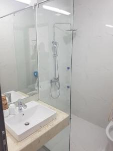 ein Bad mit einem Waschbecken und einer Glasdusche in der Unterkunft GRAD Korea Hotel 2 in Làng Thành